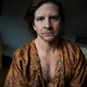 CK Swett looking like a sad grandmother with an Ellsworth Kelly plant tattoo on his chest.